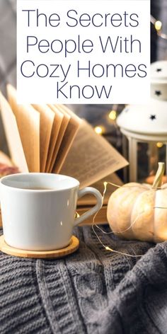 a cup of coffee on a table with an open book in the background and text overlay that reads, the secrets people with cozy homes know