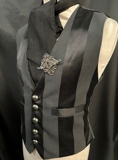 "3 items include :- waistcoat, cravat and hand crafted pin. This is a stunning black heavy suiting fabric waist coat.It is fully lined .It has wide stripes. It has  pockets and adjustable back  . It has gunmetal  buttons. It comes with a black cravat and hand crafted metal pin .  Available in two sizes:- M chest 40\" L chest 44\"  Adjustable waist . High quality well made Makes a stunning steampunk gentleman's outfit! Thank you for looking" Gothic Black Vest For Costume, Gothic Black Vest For Costume Party, Black Gothic Costume Vest, Elegant Pinstripe Vest For Formal Occasions, Steampunk Black Vest For Costume Party, Black Steampunk Vest For Costume Party, Steampunk Style Black Vest For Costumes, Steampunk Formal Sleeveless Vest, Formal Steampunk Sleeveless Vest