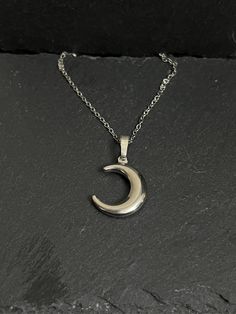 Crescent moon necklace hangs on stainless steel chain approx 18" Silver Crescent Moon Phase Necklace, Crescent Moon Phase Metal Necklace, Moon Shaped Metal Necklace With Adjustable Chain, Moon-shaped Metal Necklace With Adjustable Chain, Half Moon Metal Necklace For Gift, Half Moon Metal Necklace For Gifts, Silver Moon Charm Necklace With Adjustable Chain, Nickel Free Half Moon Silver Necklace, Silver Crescent Necklace With Adjustable Chain