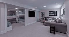 a large room with couches, bunk beds and a tv on the far wall