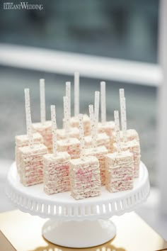 there is a cake that has been cut into squares and placed on a white platter