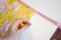 a woman is holding a piece of fabric with her hand on the edge of it