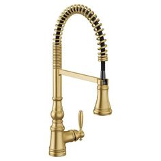 a kitchen faucet with gold colored fixtures and black hoses on the side