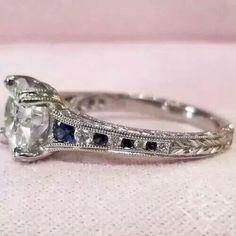 an antique style engagement ring with blue and white stones