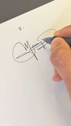 a person is writing on a piece of paper with a pen in their left hand