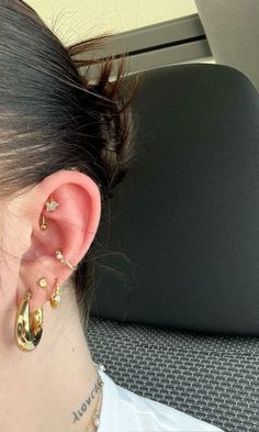 a woman wearing ear piercings in the back seat of a car