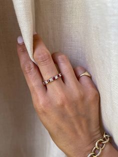 a woman's hand with a gold ring and bracelet on top of her arm