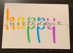 a card with the words happy written in multicolored crayons on it