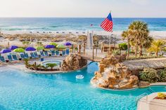 an outdoor swimming pool next to the beach