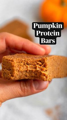 a hand holding a piece of pumpkin protein bars