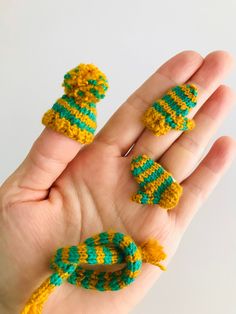 two small knitted objects in the palm of someone's hand