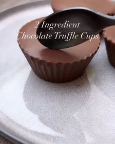 two chocolate truffle cups sitting on top of a white plate with the words 2 ingredient chocolate truffle cups