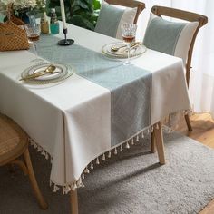 a dining room table set for two with plates and silverware on the placemats