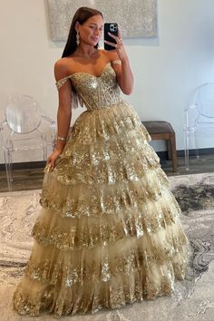 Make an unforgettable entrance in this eye-catching off-the-shoulder gold-sequin ruffle multi-layer long gown. Featuring exquisite gold-sequin lace, a deftly crafted lace-up back, and multiple layers of tulle for a luxurious effect, this showstopping dress is the perfect choice for any special occasion. Be the belle of the ball!#prom#promdresses#promgown#formaldress#formaloutfit#seniorpromdress#promgown#blacktieeventdresses Sequin Ball Gown, Tiered Tulle Skirt, Ruffle Prom Dress, Elegant Ball Gowns, Sequin Prom Dress, Evening Party Gowns, Lace Prom Dress, Dream Dresses, فستان سهرة