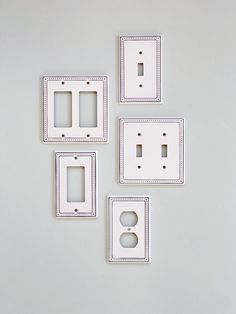 four white electrical outlet covers on a wall