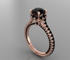 a rose gold ring with black diamonds on the sides and an oval cut diamond in the center