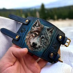 "Hand tooled leather wristband with Wolf design.  This stylish  wristband features a unique design, with a hand-crafted wolf on the front.  Crafted from high-quality leather, this wristband is both durable and stylish.  The wolf muzzle is hand-carved and hand-painted onto the leather, ensuring that each  wristband is unique and one-of-a-kind. CUSTOM orders are always available. Simply send me a message regarding whatever personalization or change you would like to add to your order, and I will r Leather Armor, Leather Wristbands, Wolf Design, Jewelry Diy Bracelets, Hand Tooled Leather, Leather Work, The Wolf, Tooled Leather, Leather Cuffs