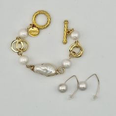 Center focal pearl is a freshwater baroque pearl wrapped in anti-tarnish gold wire. Each pearl will be unique in size and shape. Center pearl will be larger than the side pearls on the bracelet. All are genuine freshwater pearls. Easy toggle clasp. This is the gold version of the bracelet Susan wears in many of her posts on the blog from SusanAfter60, including her Being Cautious Post. As a size reference...If your wrist measures 6" you will need an 8" bracelet. Great complement for our PEARL LARIAT or PEARL EARRING. Shop the same bracelet in SILVER see it HERE Shop the Wishbone Wire (last photo) Earrings HERE At the time I made the video, only silver was available. See it layered in last photo with the Pearl Leather Cuff Bracelet. Shop with confidence.Love it or return it.We want you to l Handmade Gold Pearl Metal Bracelet, Handmade Gold Pearl Bracelet, Gold Pearl Bracelet With Oyster Detail, Adjustable Oyster Bracelet With Baroque Pearls, Adjustable Baroque Pearl Bracelet With Pearl Drop, Gold Metal Pearl Bracelet With Pearl Charm, Gold Pearl Bracelet With Metal Charm, Classic Baroque Pearl Bracelet With Pearl Drop, Baroque Pearl Drop Bracelet