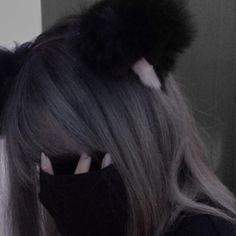 a woman with grey hair wearing a black mask and cat ears on top of her head