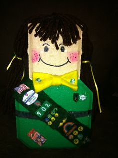 a stuffed doll with a yellow bow tie in a green box that says happy new year