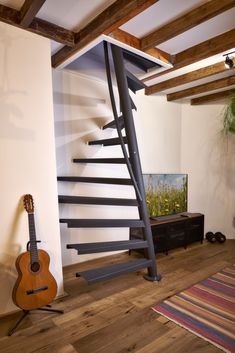 there is a guitar on the floor next to a stair case