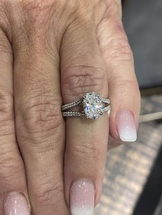 a close up of a person's hand with a diamond ring on their finger