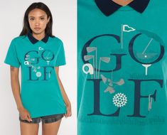 "Vintage 90s t shirt in turquoise with a golf graphic and a collar. Please see measurements and condition below. Every garment we sell is authentic vintage and one-of-a-kind! You will receive the exact item photographed. Condition: Very good vintage. Best fits women's: Labelled Medium, but runs modern small Material:  Cotton Polyester blend MEASUREMENTS Taken from seam to seam while the garment is lying flat. Double the armpit, waist, and hips For reference, model is 5'10\" and measures 31-23-34 Golf Graphic, Blue Preppy, Retro Preppy, Collar Tshirt, Golf Shirt, Golf Shirts, Vintage 90s, Graphic Tee, Gender Neutral