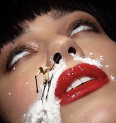 a woman with snow on her face and skis sticking out of her mouth