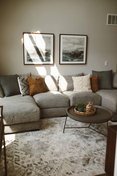 a living room filled with furniture and pictures on the wall above it's coffee table