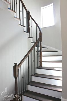 a staircase with white walls and wooden handrails