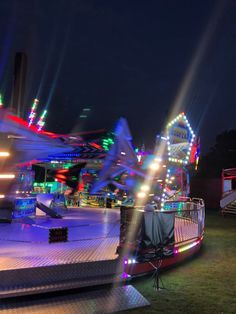 an amusement park at night with lights and rides