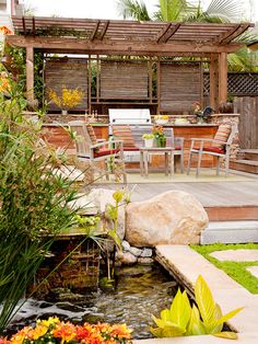 an outdoor patio and dining area with water feature in the center, surrounded by greenery