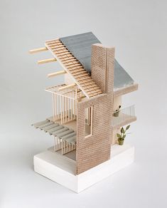 a model of a house made out of wood and wicker with stairs leading up to the roof