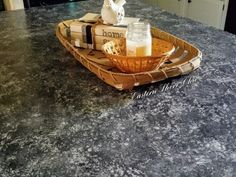 a kitchen counter with a basket on top of it and two bottles in the middle