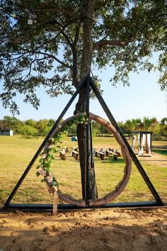 a triangle shaped sculpture in the middle of a field