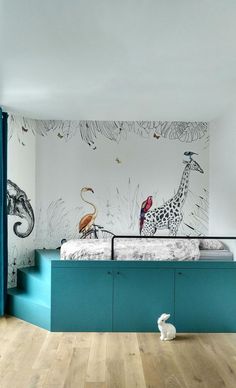 a child's bedroom with blue and white walls, an animal mural on the wall