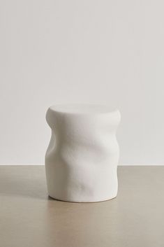 a white vase sitting on top of a table