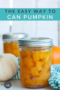 two jars filled with canned pumpkins sitting on top of a table next to an orange and white pumpkin