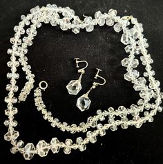 "What an amazing find! Buy one or all 3 of these rock crystal pieces from the 1920s! Perfect for a wedding day or any time you need a little extra sparkle. Let's start with the earrings. The chunky cut rock crystal screw backs are suspended by some kind of white pot metal with what looks like a white paste at the ear. They are about 37mm long and the rock crystal is faceted on all sides. Its a particularly lovely cut with wonderful prismatic effects-- I had a rainy day for photos but I will try to update when I have sun. The rock crystal chunks are about 16mmx13mm. The first necklace is choker length, about 16 inches long, with rondelle style faceted graduated rock crystal beads that range in size from 15mm to 7mm in diameter and more diamond shaped rondelle spacer beads. It seems to be on Hook Clasp, Metal Hooks, White Silk, Rock Crystal, Spacer Beads, Spring Rings, Diamond Shapes, Crystal Beads, Earring Set