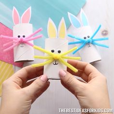 someone is holding up some paper with bunny ears on it and two rabbits made out of toilet paper