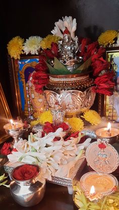 there are many flowers and candles on the table