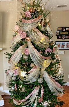 a christmas tree decorated with ribbons and flowers