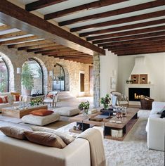 a living room filled with lots of furniture next to a fire place in a house