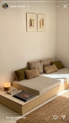 a bed sitting on top of a wooden platform next to a wall with pictures above it