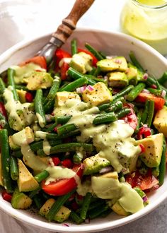 a white bowl filled with vegetables and dressing