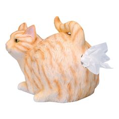 an orange and white cat figurine with tissue paper in its mouth