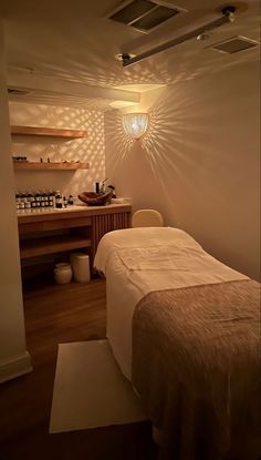 a spa room with a bed, sink and shelves filled with bottles on the wall