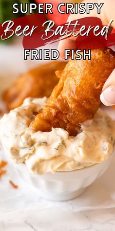 a person dipping some kind of food into a small white bowl with sauce on it