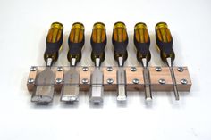 six screwdrivers are lined up next to each other on a piece of wood