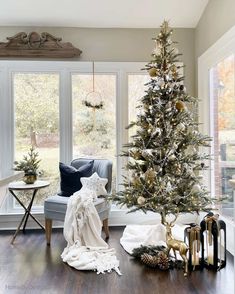 a living room with a christmas tree in the corner and other decorations on the floor